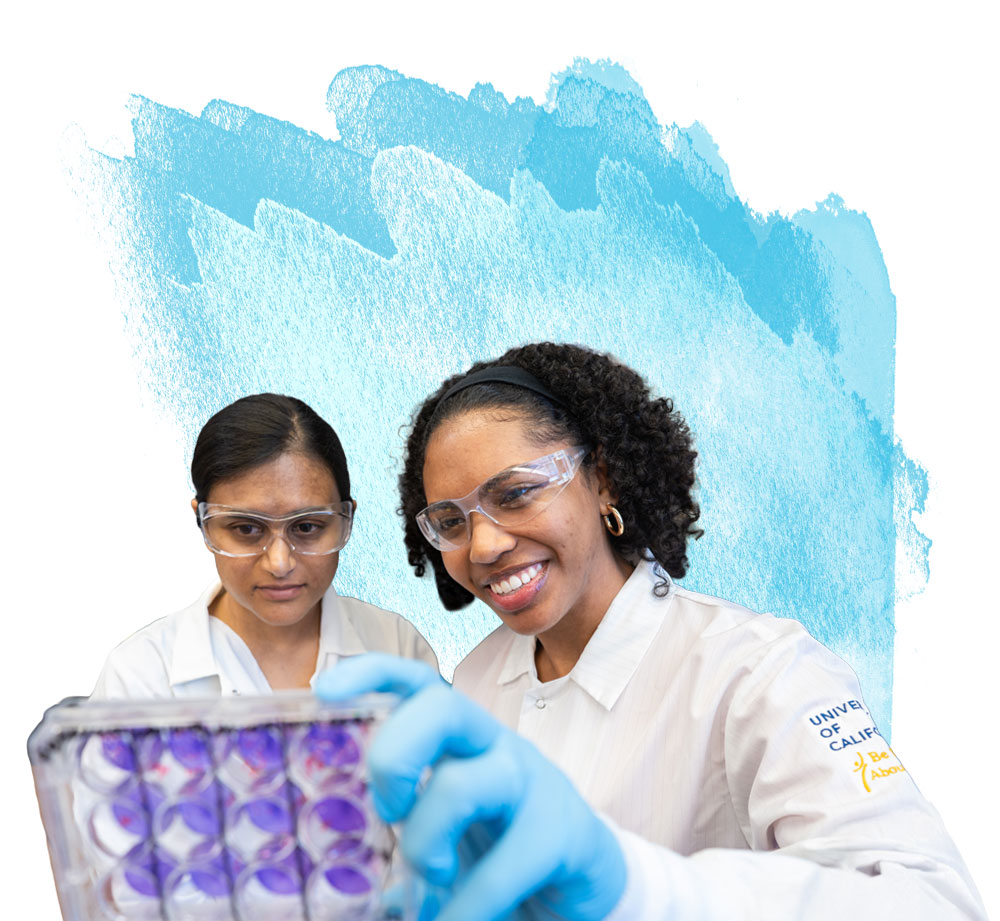 Two researchers in white lab coats and safety glasses examine a tray of purple-stained samples. One wears gloves and smiles while holding the tray. A blue watercolor background appears behind them.