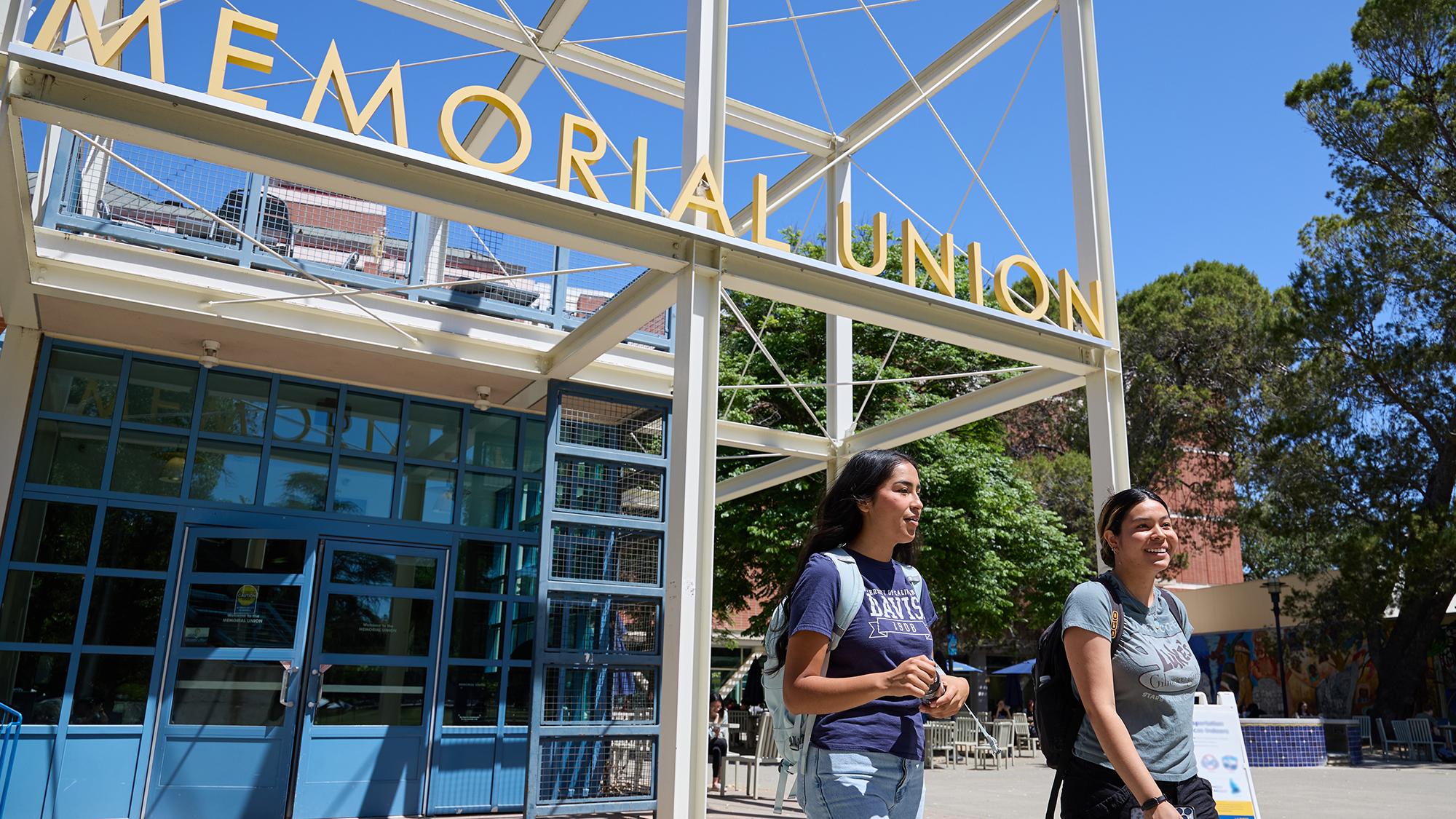 Two people walking in front of the Memorial Union